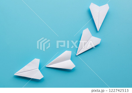 Top view of origami white paper airplane pioneering the path with leadership in motion Top view of origami white paper airplane pioneering the path with leadership in motion 122742513