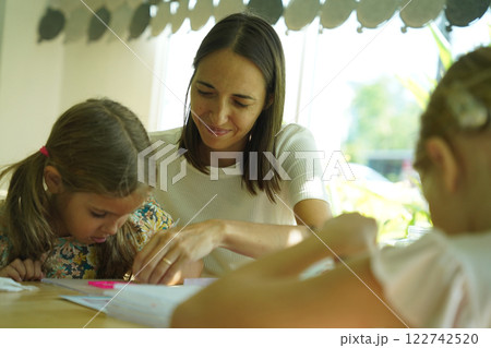 Teacher in workshop teched two girls how to assemble a thermo mosaic  122742520