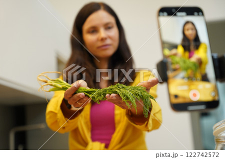 Young woman is broadcasting live from workshop how to prepare a vegetarian food Young woman is broadcasting live from workshop how to prepare a vegetarian food 122742572