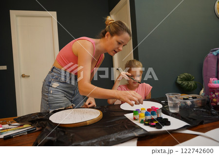 A mother and her young daughter engage in a colorful painting activity A mother and her young daughter engage in a colorful painting activity 122742600
