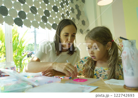Teacher in workshop teched two girls how to assemble a thermo mosaic  122742693