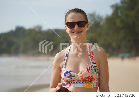 A young woman enjoying a beautiful day at the beach A young woman enjoying a beautiful day at the beach 122742820