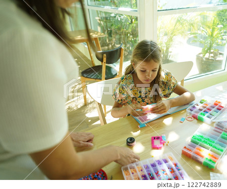 Teacher in workshop teched two girls how to assemble a thermo mosaic  122742889