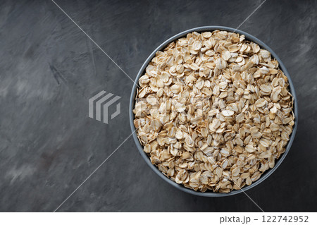 Uncooked Rolled Oats in Bowl for Vegan Breakfast and Weight Loss Nutrition, Copy Space Uncooked Rolled Oats in Bowl for Vegan Breakfast and Weight Loss Nutrition, Copy Space 122742952