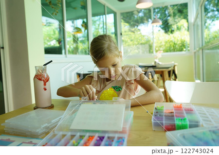 Teacher in workshop teched two girls how to assemble a thermo mosaic  122743024