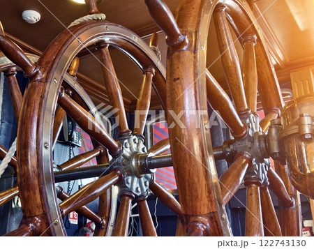 A row of wooden steering wheels located on an old vessel A row of wooden steering wheels located on an old vessel 122743130