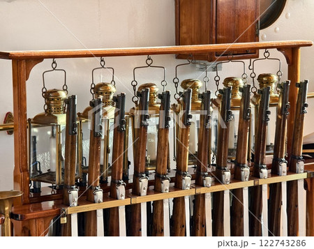 A row of decorative rifles is lined up on a wooden rack A row of decorative rifles is lined up on a wooden rack 122743286