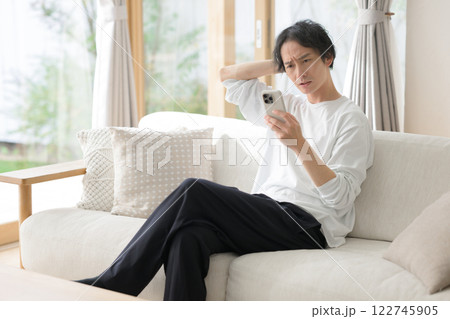 スマホを使う男性 悩む 困る スマホを使う男性 悩む 困る 122745905