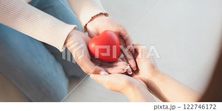 Closeup view of red heart on woman and man hands Closeup view of red heart on woman and man hands 122746172