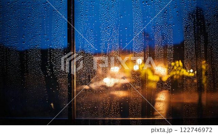 夜に降る雨のガラス窓についた水滴・雨粒の背景素材 122746972