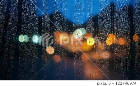 夜に降る雨のガラス窓についた水滴・雨粒の背景素材 122746974