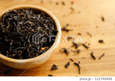 Japanese or Chinese jasmine tea leaf in wooden bowl on wooden background. 122748408
