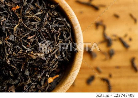 Japanese or Chinese jasmine tea leaf in wooden bowl on wooden background. 122748409