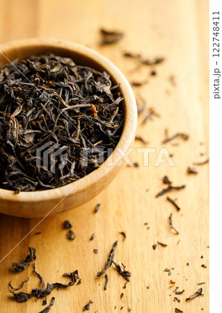 Japanese or Chinese jasmine tea leaf in wooden bowl on wooden background. 122748411