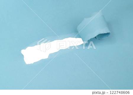 Hole in paper blue color background damaged ripped Hole in paper blue color background damaged ripped 122748606
