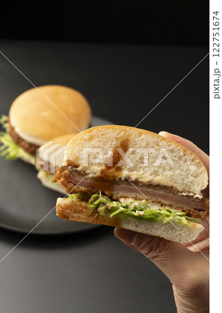 ハムカツバーガーを手で持ち上げる ハムカツバーガーを手で持ち上げる 122751674