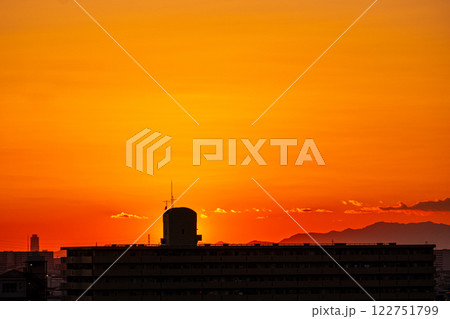 鮮やかなオレンジ色の夕焼けと都市のシルエット 鮮やかなオレンジ色の夕焼けと都市のシルエット 122751799