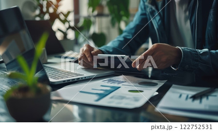 Modern Financial Planning: Hands on Tablet with Laptop and Documents in Stylish Workspace 122752531
