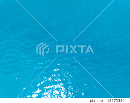 Aerial view of blue sea surface water texture background,Sun reflections on water, Aerial flying drone view Waves water surface texture on sunny tropical ocean in Phuket island Thailand 122753594