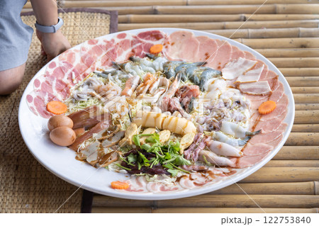Huge Shabu is a dish made of raw pork and chicken meat, tofu, and a few vegetables. blanch in a pot of hot water. 122753840