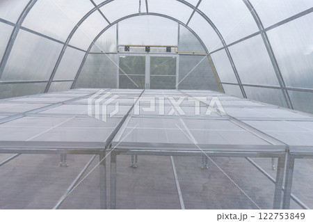 Greenhouse for organic vegetables. The thatched roof will keep out bugs. 122753849