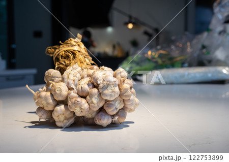 Garlic Bundle in studio light on the white marble surface table, prepare for a food demonstration behind. 122753899