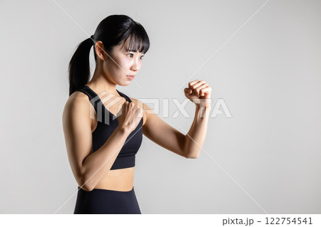 ファイティングポーズをするスポーツウェアの女性 122754541