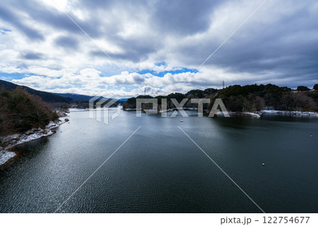 雪景色の奈良布目ダム　雲間から覗く青空と光り輝く湖面 122754677