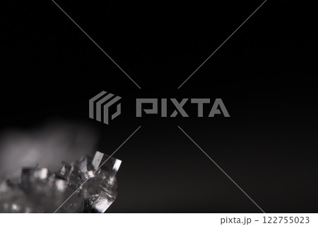 Transparent crystal on black background, minimalistic photo, place for inscription, dark copy space, salt crystals 122755023