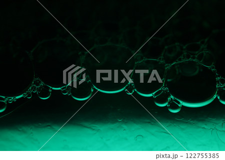 Green liquid surface, fantastic bubbles connections, fluid movement, dark fantastic background, transparent forms, black and green 122755385