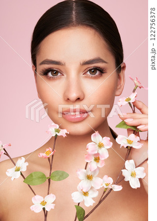 Beautiful young woman with a cherry blossom branch Beautiful young woman with a cherry blossom branch 122756378