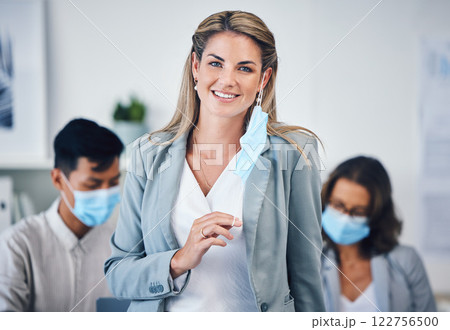 Portrait of a business woman in her office with a face mask and her team during covid pandemic. Corporate, creative and professional manager working on a group project in the company conference room. 122756500