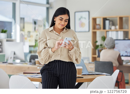 Entrepreneur on phone with social media online in a modern office. Business woman smile while chatting and checking email at work or sharing good news of a successful startup with a mobile smartphone Entrepreneur on phone with social media online in a modern office. Business woman smile while chatting and checking email at work or sharing good news of a successful startup with a mobile smartphone 122756720