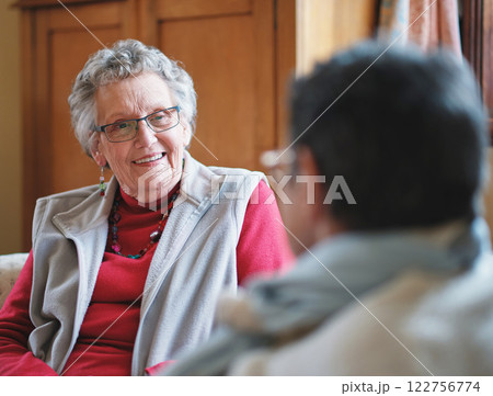 Elderly woman, talking and friends in home together or retirement connection, communication or relax. Female person, smile and conversation bonding for speaking in lounge for love, care or support Elderly woman, talking and friends in home together or retirement connection, communication or relax. Female person, smile and conversation bonding for speaking in lounge for love, care or support 122756774