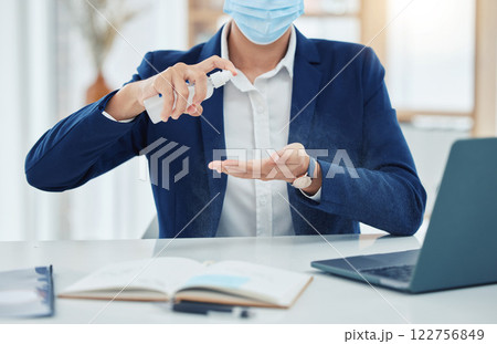 Businessman spray cleaning with a covid mask while working in an office. Entrepreneur cleaning and disinfecting his hands to prevent the spread of germs, corona and infection in the covid pandemic Businessman spray cleaning with a covid mask while working in an office. Entrepreneur cleaning and disinfecting his hands to prevent the spread of germs, corona and infection in the covid pandemic 122756849