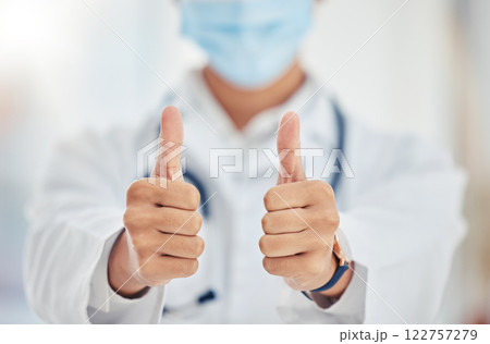 Thumbs up doctor hand sign for covid surgery success, support and yes in a hospital. Medical and healthcare worker showing thank you, agreement or goal completion hands gesture in a health clinic 122757279
