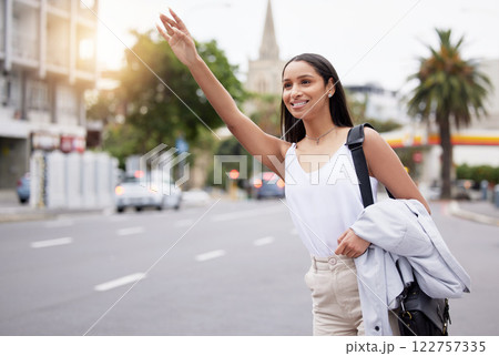 Happy woman showing hand sign for a taxi while standing in a street in the city, business travel for a meeting or event. smiling female on her daily commute, gesture hail cab while on a trip downtown 122757335