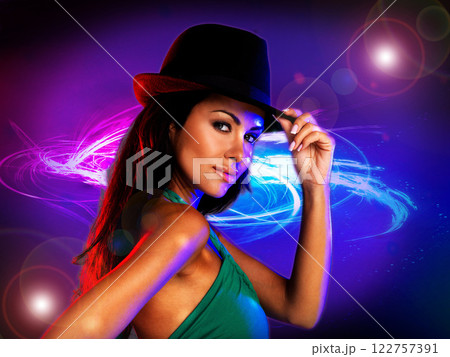 Fashion, disco and sexy woman model posing for a night party, dance and DJ music in style. Attractive female in dancing club promotion for techno, rave or concert on colorful flare light background. 122757391
