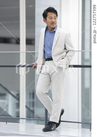 白のセットアップを着た50代半ばの男性 122757399
