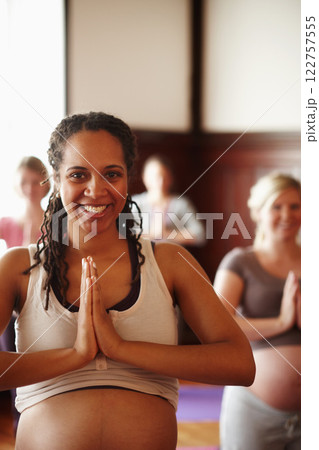 Wellness, yoga and meditation of pregnant friends or women with spiritual, health and healthy lifestyle with prayer hands sign. Portrait of happy mother to be in yoga class with smile in a zen studio 122757555