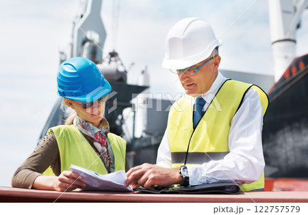 Logistics worker, employee and people doing administration with document, planning construction at work and team working manufacturing industry. Man and woman reading paper and talking about project 122757579