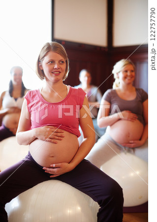 Exercise class, pregnant mother fitness and women workout at maternity wellness care studio. Happy woman with pregnancy belly on gym ball with the motivation for a strong and healthy body. Exercise class, pregnant mother fitness and women workout at maternity wellness care studio. Happy woman with pregnancy belly on gym ball with the motivation for a strong and healthy body. 122757790