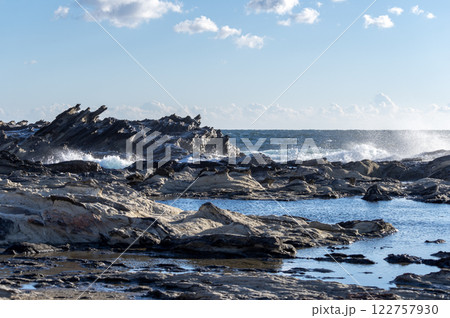 冬の晴れた日の磯に打ち付ける波 122757930