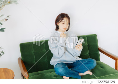 ソファでスマホを使う女性 ソファでスマホを使う女性 122758129