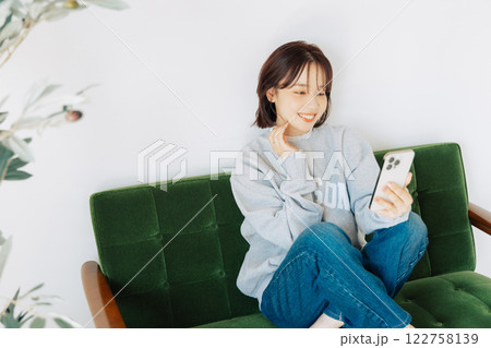 ソファでスマホを使う女性　 122758139