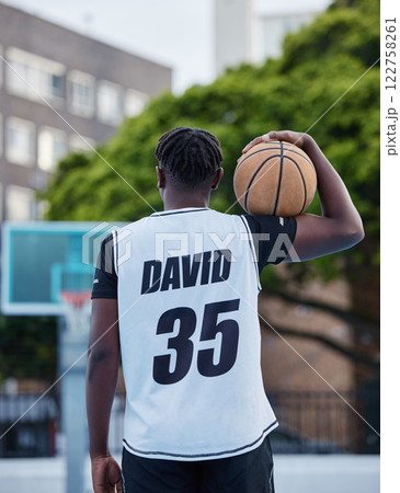 Basketball, sports and fitness exercise of a sport player on an outdoors court for a workout. Back of a strong man and athlete with a ball ready to start cardio, active or game match training outside Basketball, sports and fitness exercise of a sport player on an outdoors court for a workout. Back of a strong man and athlete with a ball ready to start cardio, active or game match training outside 122758261