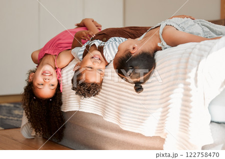 Kids lying on bed playful, fun and silly generation with cute hairstyle and smiling portrait. Relaxing, playing indoors showing growth, child development and childhood innocence from little siblings. 122758470
