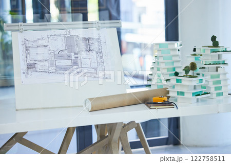Architecture, design and blueprints on an office desk with plans and a building model for the construction industry. Architect office, planning and equipment in a modern and creative workplace Architecture, design and blueprints on an office desk with plans and a building model for the construction industry. Architect office, planning and equipment in a modern and creative workplace 122758511