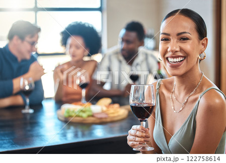Social, happy and wine of a woman with a glass of alcohol at a dinner table with friends in a restaurant. Young female with smile in luxury fun dining with people at a celebration or event indoors. 122758614