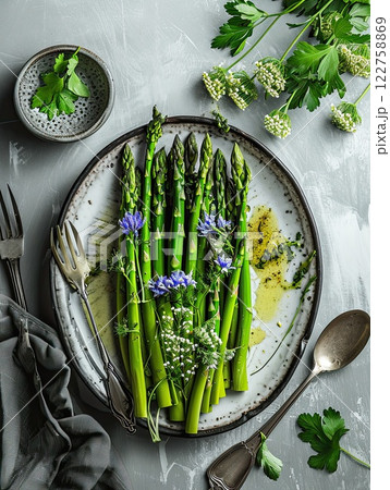 Green asparagus sprouts in plate with eadible flowers, 122758869